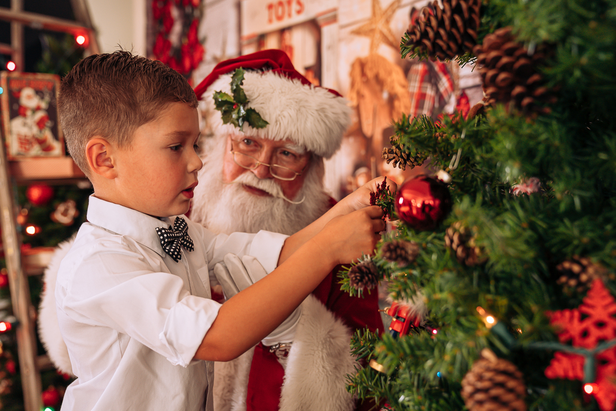Santa and young boy decoration Christmas tree at Santa Sessions by Gary Evans Photography
